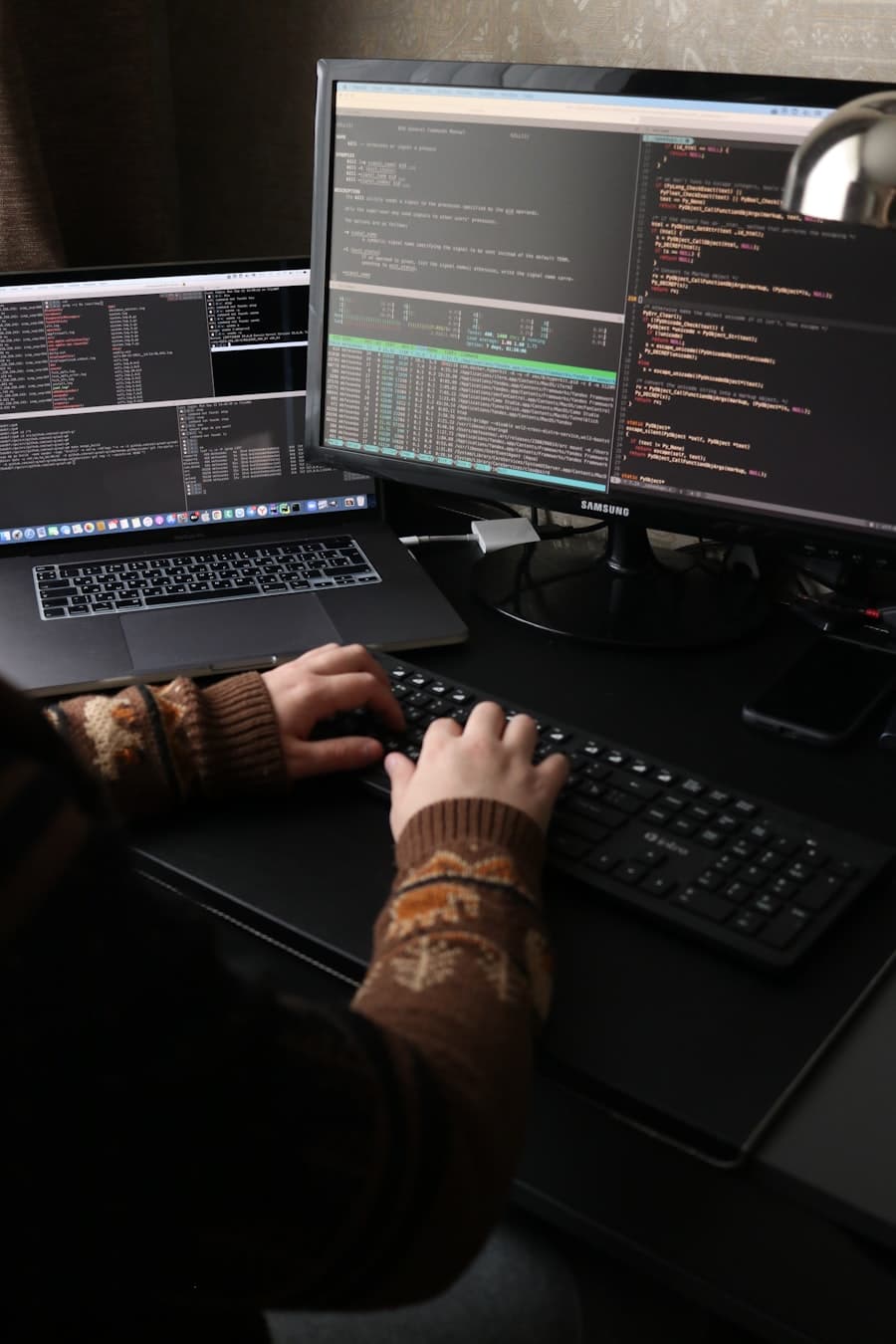 Hands typing on a keyboard in front of an editor